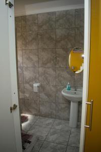 La salle de bains est pourvue d'un lavabo, de toilettes et d'une douche. dans l'établissement Josef Self Catering, à Swakopmund