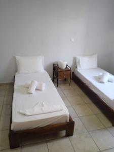 2 łóżka pojedyncze w pokoju ze stołem w obiekcie Μονοκατοικία στην Σύρος w mieście Ermupoli