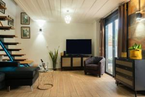 a living room with a tv and a couch and a chair at Bienvenue à la Marine de St Benoit 1 in Saint-Benoît