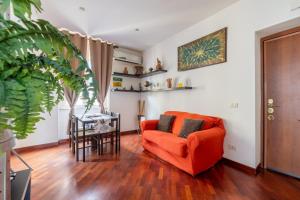 ein Wohnzimmer mit einem orangenen Sofa und einem Tisch in der Unterkunft Smart Lodging Downtown in Rom