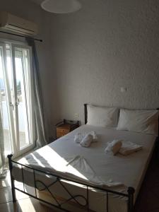 Una cama con sábanas blancas y almohadas. en Μονοκατοικία στην Σύρος en Ermúpoli