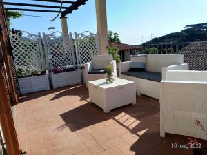 un patio con divano e tavolo sul balcone. di La casa accanto a Rio nellʼElba