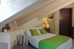 um quarto com uma cama e uma secretária com almofadas verdes em A un passo da Porta Nuova e dal centro: Io&Te em Turim