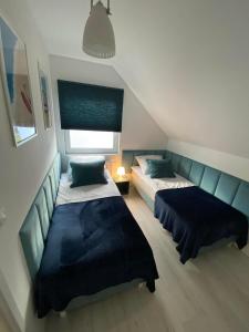 1 dormitorio con 2 camas y ventana en Apartament, en Władysławowo
