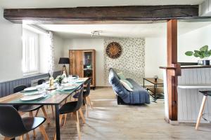 una sala da pranzo con tavolo e sedie di Appartement Le Spacieux Bressan - Hyper-Centre a Bourg-en-Bresse