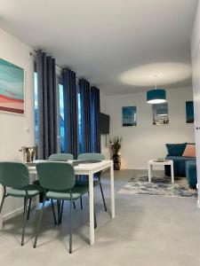 sala de estar con mesa, sillas y sofá en Apartament, en Władysławowo