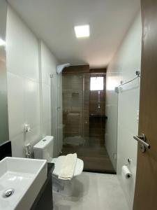 a bathroom with a toilet and a sink and a shower at Lindo flat no Maui Beach Residence C201 in Tamandaré +12 photos