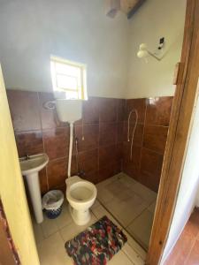 a bathroom with a toilet and a sink at Chalé Boa Vista in Carrancas