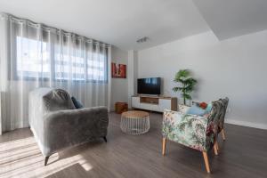 a living room with two chairs and a television at Apartamento Estepona I in Estepona