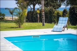 a blue chair sitting next to a swimming pool at Katerina House in Perivolia