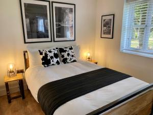 Schlafzimmer mit einem Bett mit schwarzen und weißen Kissen in der Unterkunft Booking Urban at Stisted in Braintree