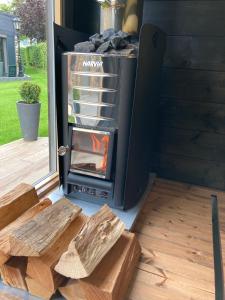 a wood stove in a tiny house with logs at Valley View B&B with private wellness in Bullange