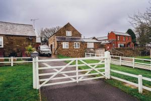 una cerca blanca frente a una casa en Cottages In Derbyshire - Apple Cottage en Belper