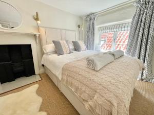 a bedroom with two beds and a fireplace at Normanby Cottage Runswick Bay in Runswick