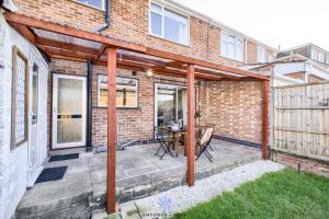 a patio with a table in a brick building at Coventry Spacious Luxury 3 Bed House, Private Parking, Sleeps 8, by EMPOWER HOMES in Wyken