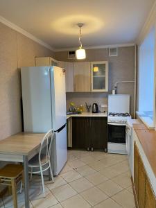 een keuken met een witte koelkast en een tafel en stoelen bij Сдам квартиры посуточно in Köksetaw