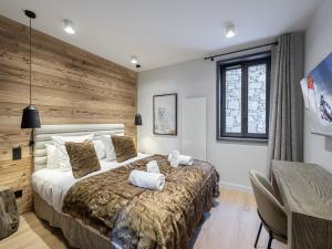 ein Schlafzimmer mit einem großen Bett und einer Holzwand in der Unterkunft Appartement Courchevel 1550, 6 pièces, 8 personnes - FR-1-562-63 in Courchevel