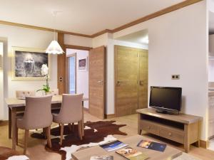 a living room with a dining room table and a television at Appartement Courchevel 1550, 2 pièces, 4 personnes - FR-1-562-52 in Courchevel