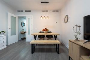 a dining room with a table and a bench at Apartamento Estepona II in Estepona