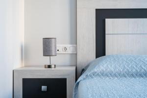 een slaapkamer met een bed en een lamp op een nachtkastje bij Apartamento Estepona II in Estepona