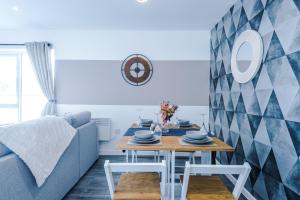 a living room with a table and a blue couch at Formby Village Apartments By Greenstay Serviced Accommodation - Perfect For LONG STAYS - Couples, Families, Business Travellers & Contractors All Welcome - 7 in Formby