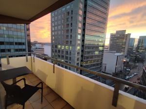 a balcony with a chair and a view of a city at ZEN Apartment - spacious for 7 - central - kitchen in Offenbach