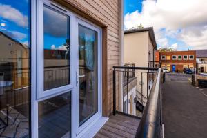 a balcony with a sliding glass door with a view of a street at Stunning 2 Bed Apt By Greenstay Serviced Accommodation - Perfect For SHORT & LONG STAYS - Couples, Families, Business Travellers & Contractors All Welcome - 7 in Formby