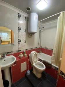 a bathroom with a white toilet and a sink at Сдам квартиры посуточно in Kokshetau