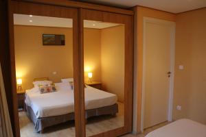 1 dormitorio con cama y espejo. en Villa Vista Mare Residence Serenamore en Favone