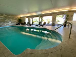 une grande piscine dans un hôtel avec des chaises dans l'établissement Parc Hôtel, à Wangenbourg