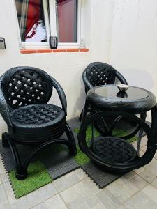2 sedie nere e un tavolo sul patio di Douceur d’une nuit (studio avec jaccuzi privatif) a Vitrolles