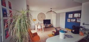 a living room with a couch and a table with a plant at Disneyland cosy Apartment in Montévrain