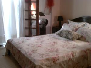 um quarto com uma cama com um cobertor florido e almofadas em just simple em Kalamata