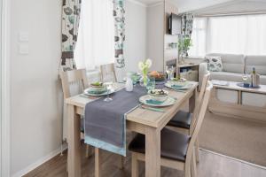 uma cozinha e sala de jantar com mesa e cadeiras em 56 Seabreeze em Milford on Sea
