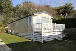 a tiny house with a white fence at 56 Seabreeze in Milford on Sea