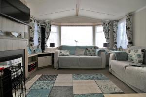 ein Wohnzimmer mit einem Sofa und einem Stuhl in der Unterkunft 56 Seabreeze in Milford on Sea