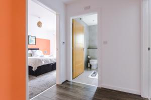 a bedroom with a bed and a door leading to a bathroom at Luxury 2 Bedroom Apartment With FREE Parking In Formby Village By Greenstay Serviced Accommodation - Perfect for Couples, Families & Business Travellers in Formby