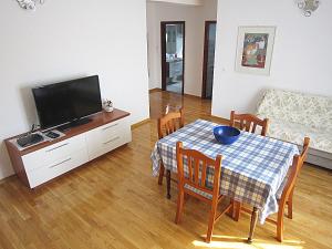 uma sala de estar com uma mesa e uma televisão em Villa Lucia premium rooms em Primošten