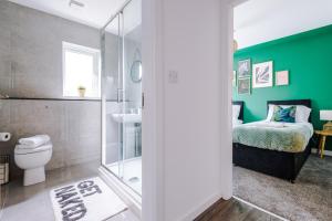 a bathroom with a toilet and a green wall at Luxury 2 Bedroom Apartment With FREE Parking In Formby Village By Greenstay Serviced Accommodation - Perfect for Couples, Families & Business Travellers in Formby