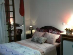 a bedroom with a bed with two pillows on it at just simple in Kalamata