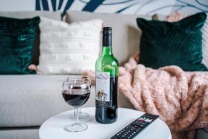 a bottle of wine and a glass on a table at Luxury 2 Bedroom Apartment with FREE Parking In Formby Village By Greenstay Serviced Accommodation - Perfect for Couples, Friends & Families & Business Travellers - Dog Friendly - 6 in Formby +8 photos