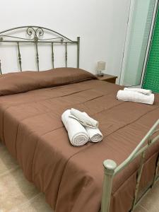 Una cama con dos toallas encima. en Roomors Of Naples - Sea View Apartment en Nápoles