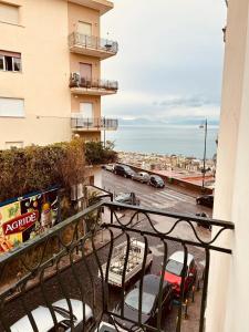 a balcony with chairs and a view of a parking lot at Roomors Of Naples - Sea View Apartment in Naples