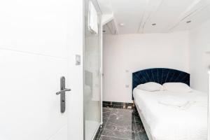 Dormitorio pequeño con cama y ducha en Studio balnéo - Centre-ville, en Chalon-sur-Saône