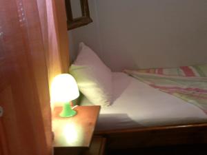 a small bed with a lamp on a table at just simple in Kalamata