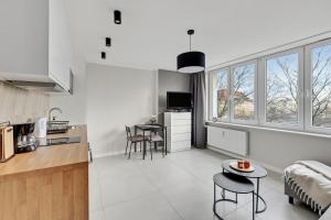 kuchnia i salon ze stołem i krzesłami w obiekcie Comfort Apartments Morska w mieście Gdynia