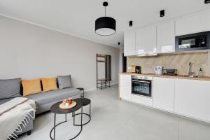 a living room with a couch and a table at Comfort Apartments Morska in Gdynia