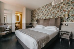 a bedroom with a large bed with a floral wall at Unica Suites Rome in Rome