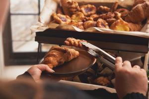 a person holding a plate of food with pastries at The Old Success Inn in Sennen Cove