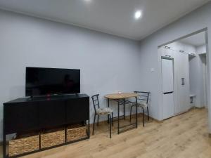 亞斯珊別茲魯伊的住宿－Apartament w Centrum，客厅配有桌子和平面电视。